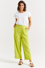 A model wearing the Parker Pant in colour Limegreen (Green), from the front, showing the whole outfit