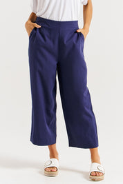 A model wearing the Parker Pant in colour Navy (Blue), from the front, cropped image