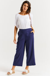 A model wearing the Parker Pant in colour Navy (Blue), from the front, showing the whole outfit