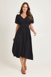 Model Madeline wearing size 10 of the Dahlia Dress in colour Black (Black), from the front, showing the whole outfit