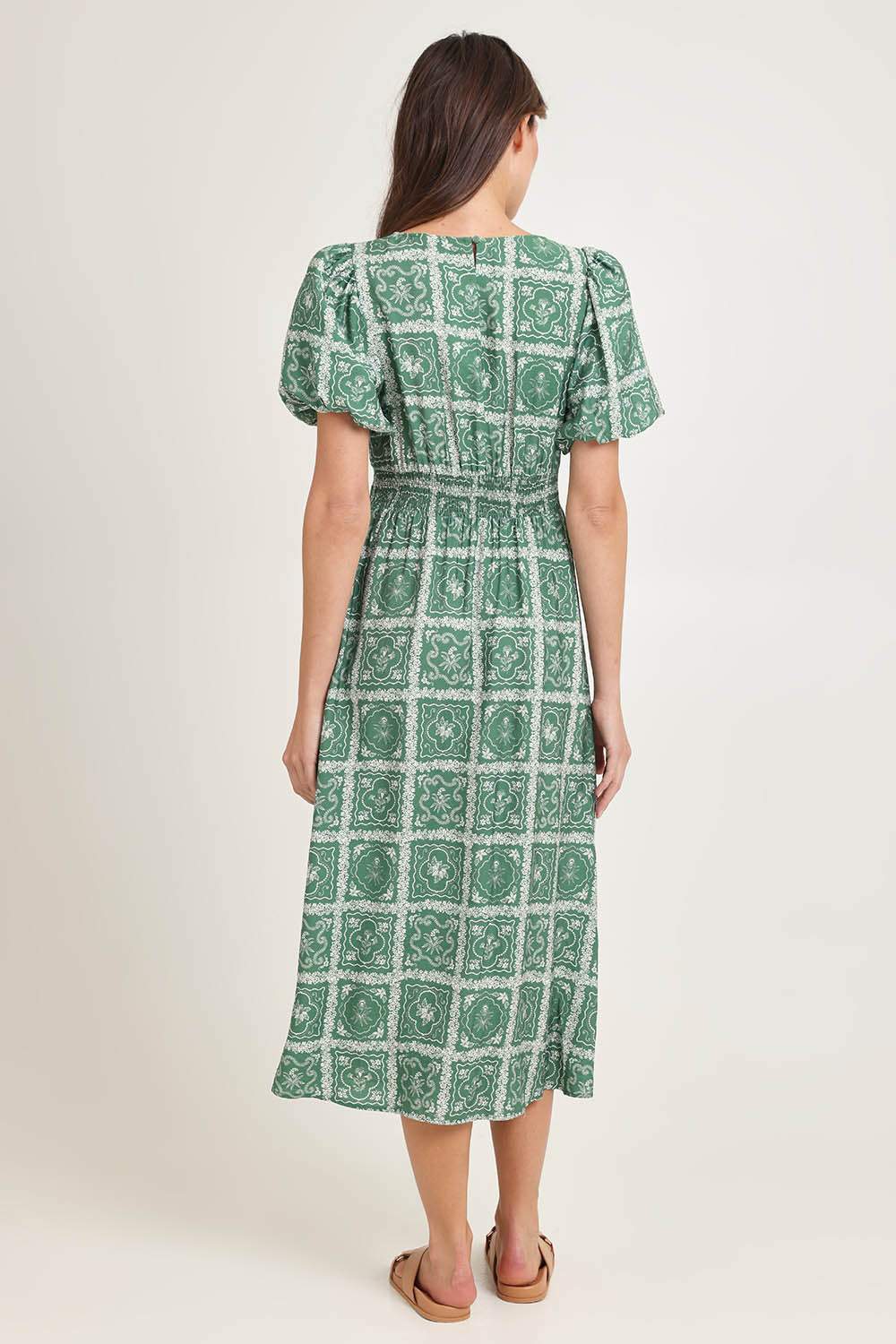 Model Madeline wearing size 10 of the Dahlia Dress in colour Floral (Green), from the back