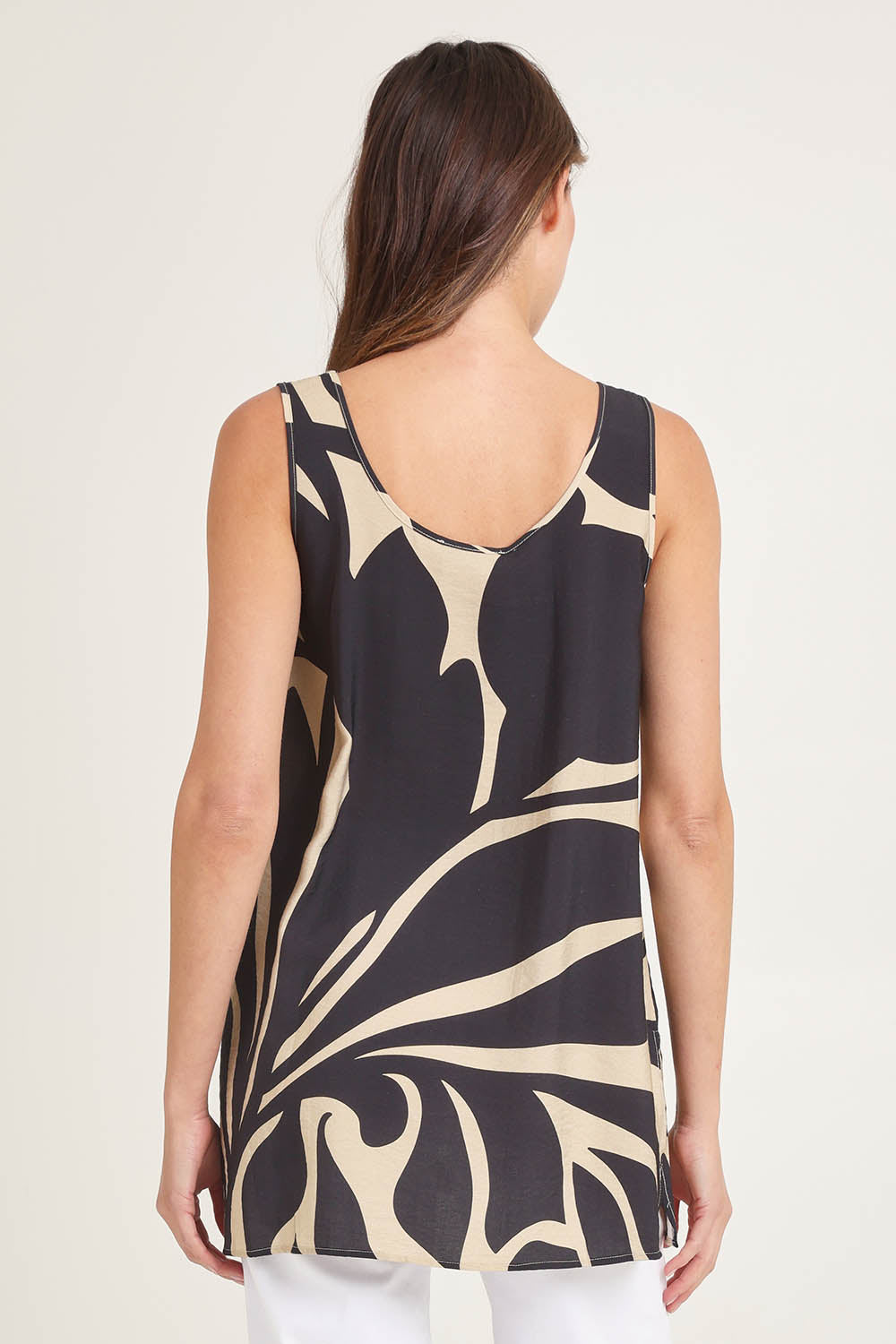 Model Madeline wearing size 10 of the Lana Tunic Tank in colour Floral (Black), from the back