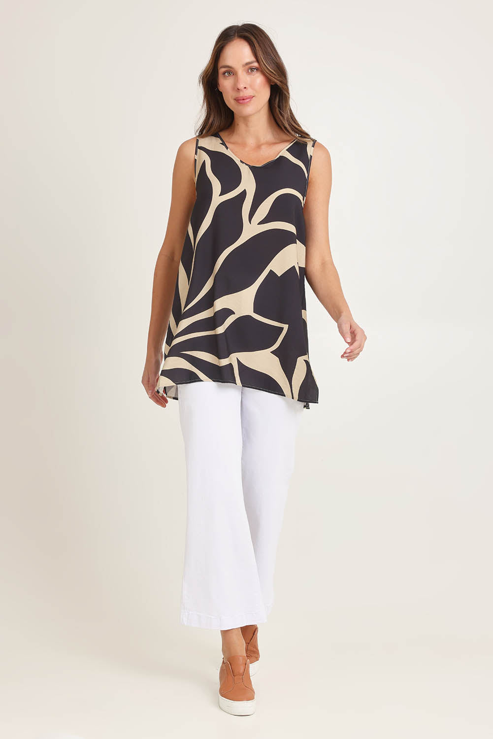 Model Madeline wearing size 10 of the Lana Tunic Tank in colour Floral (Black), from the front, showing the whole outfit