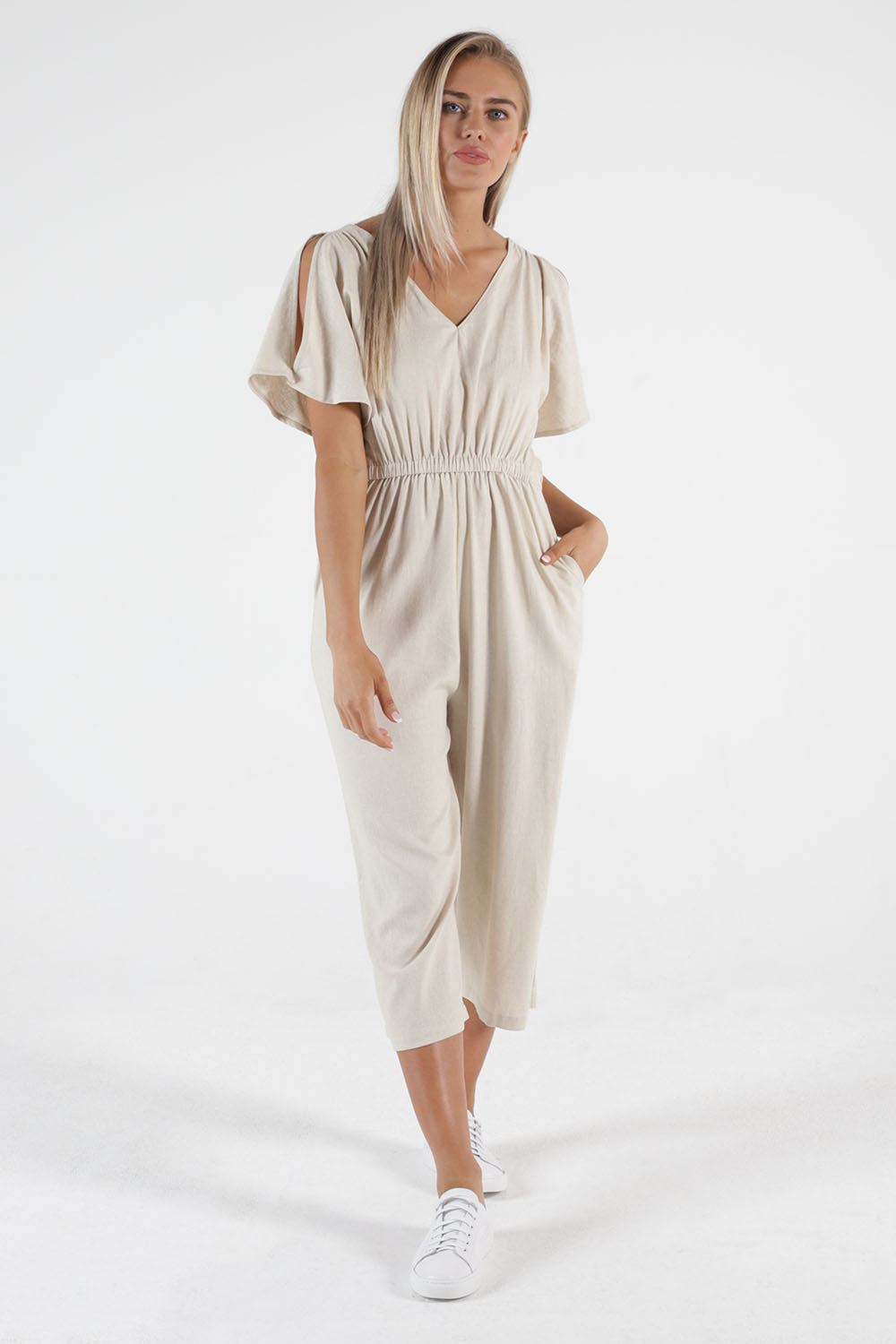 A model wearing the Jules Linen Jumpsuit in colour Wheat, from the front, showing the whole outfit