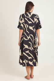 Model Madeline wearing size 10 of the Camille Dress in colour Floral (Black), from the back