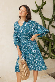 Model Genericm wearing size sample of the Bella Dress – Teal in colour Teal, from an angle