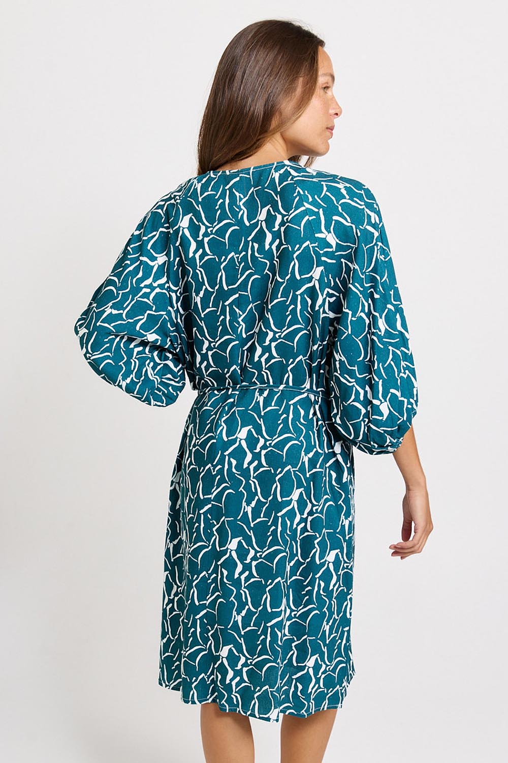 Model Genericm wearing size sample of the Bella Dress – Teal in colour Teal, from the back