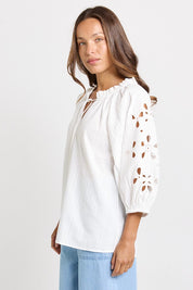 Model Genericm wearing size sample of the Daisy Broderie Blouse – White in colour White, from an angle