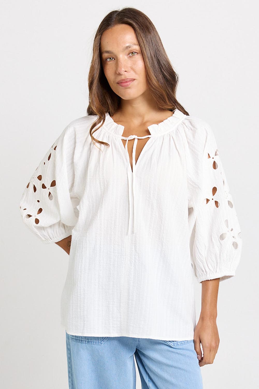 Model Genericm wearing size sample of the Daisy Broderie Blouse – White in colour White, in a cropped view