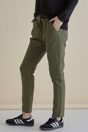 A model wearing the Dakota Denim Pant in colour Khaki (Green), from the front, cropped image