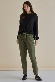 A model wearing the Dakota Denim Pant in colour Khaki (Green), from the front, showing the whole outfit