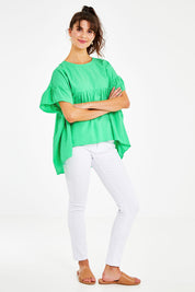 Model Courtney wearing size 10 of the Dana Top in colour Celery (Green), from the front, showing the whole outfit