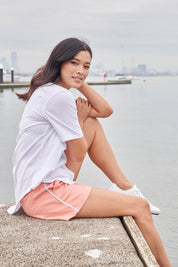 A model wearing the Debbie Denim Jogger Shorts in colour Peachpink (Pink), from the front, showing the whole outfit
