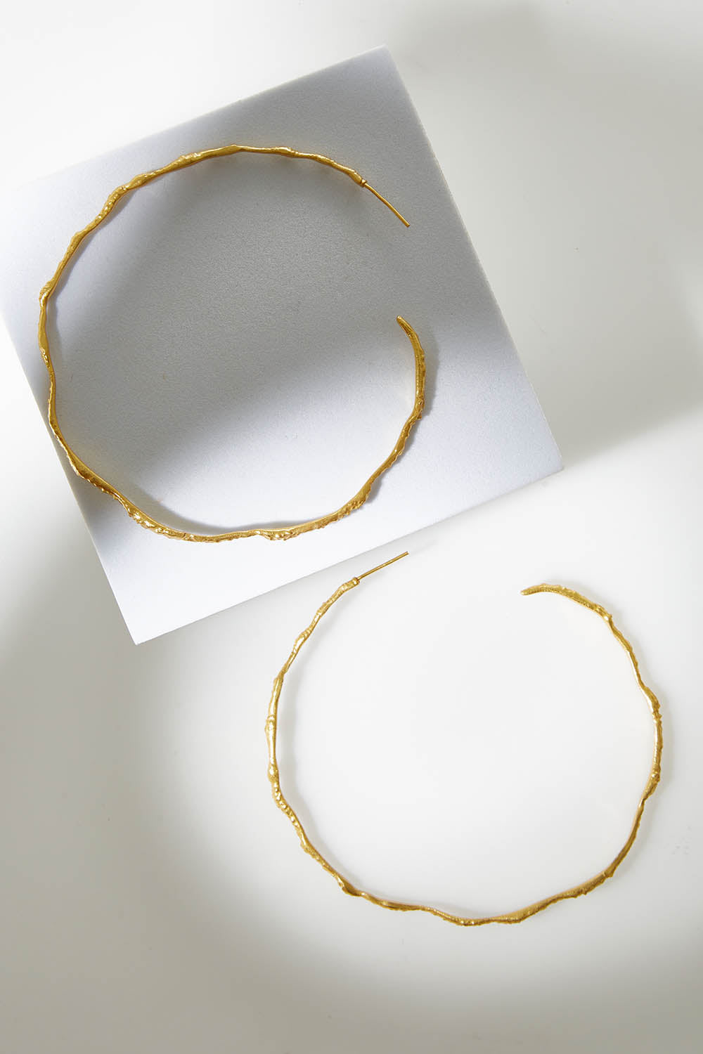 A model wearing size OneSize of the Hammered Brass Open Hoops in colour Goldbrass (Metallics), from the front, showing the whole outfit