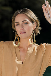 Model Tegan wearing size OneSize of the Brass Oversize Earrings in colour Goldbrass (Metallics), from the front, showing the whole outfit