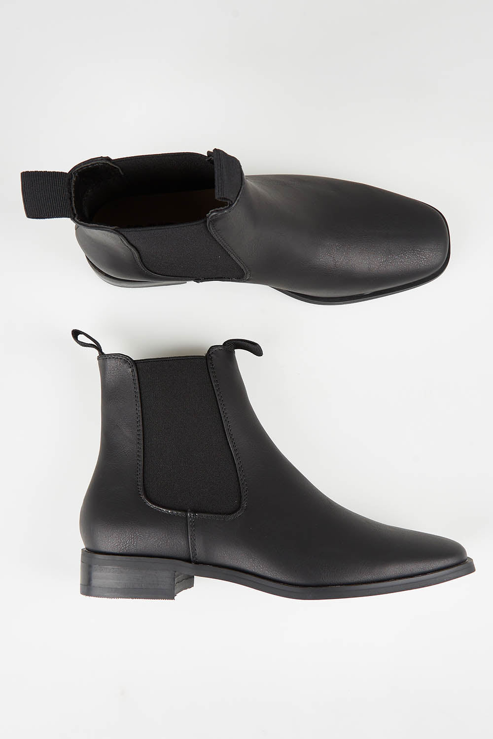 A model wearing size 37 of the Vegan Leather Pull On Flat Boot in colour Black (Black), from the front, showing the whole outfit