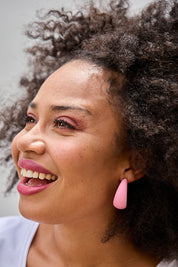 Model Olivia wearing size OneSize of the Coloured Hoop Earrings in colour Palepink (Pink), from the front, showing the whole outfit