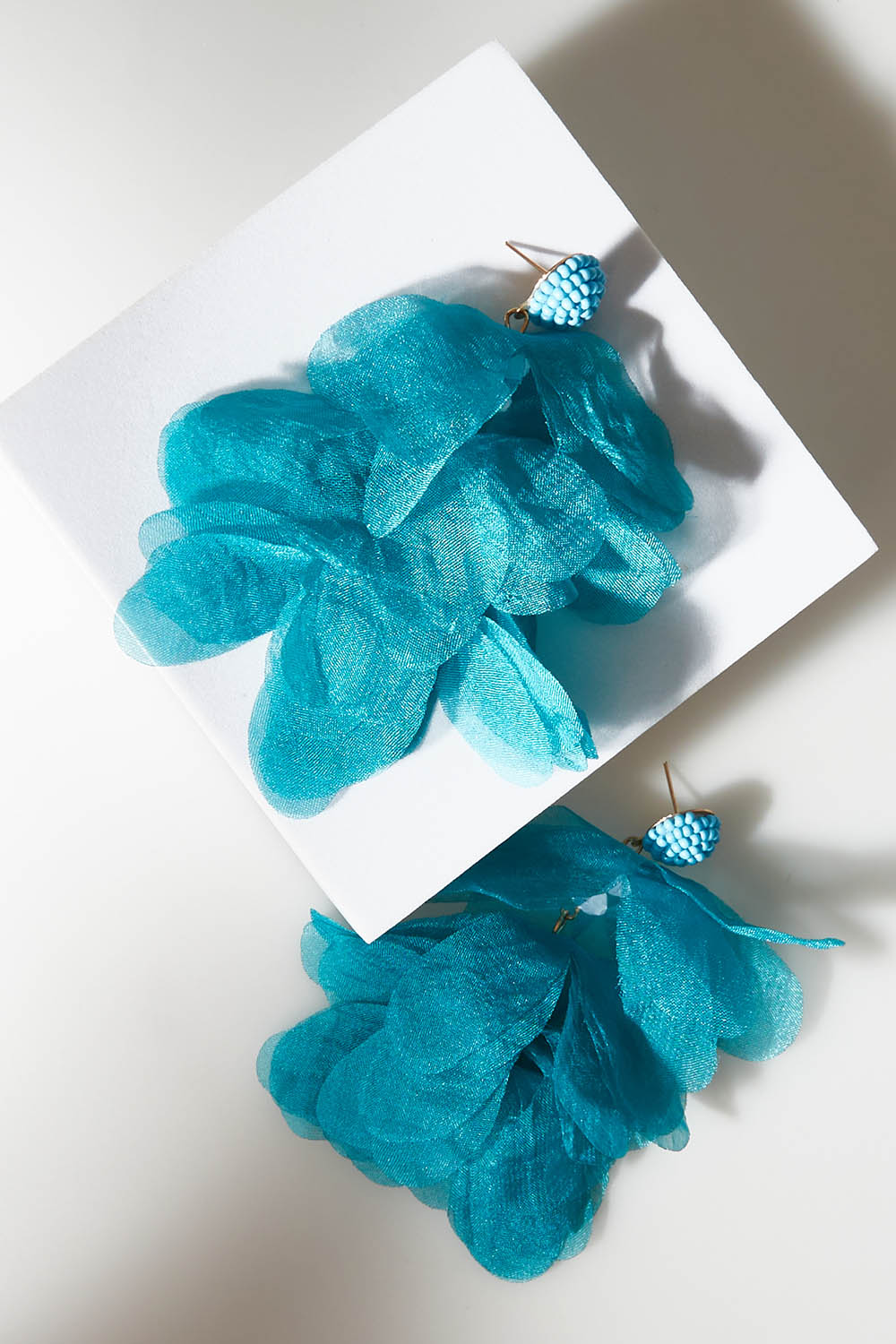 A model wearing size OneSize of the Bunch of Colour Earrings in colour Teal (Blue), from the front, showing the whole outfit