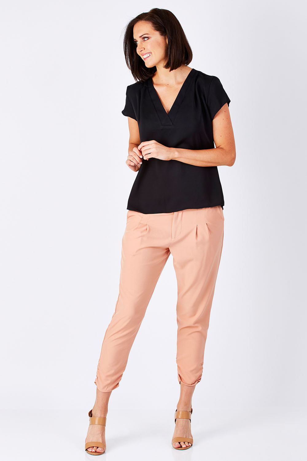 Model Perrie wearing size 10 of The Best Seller Pant in colour Clay (Pink), from the front, showing the whole outfit