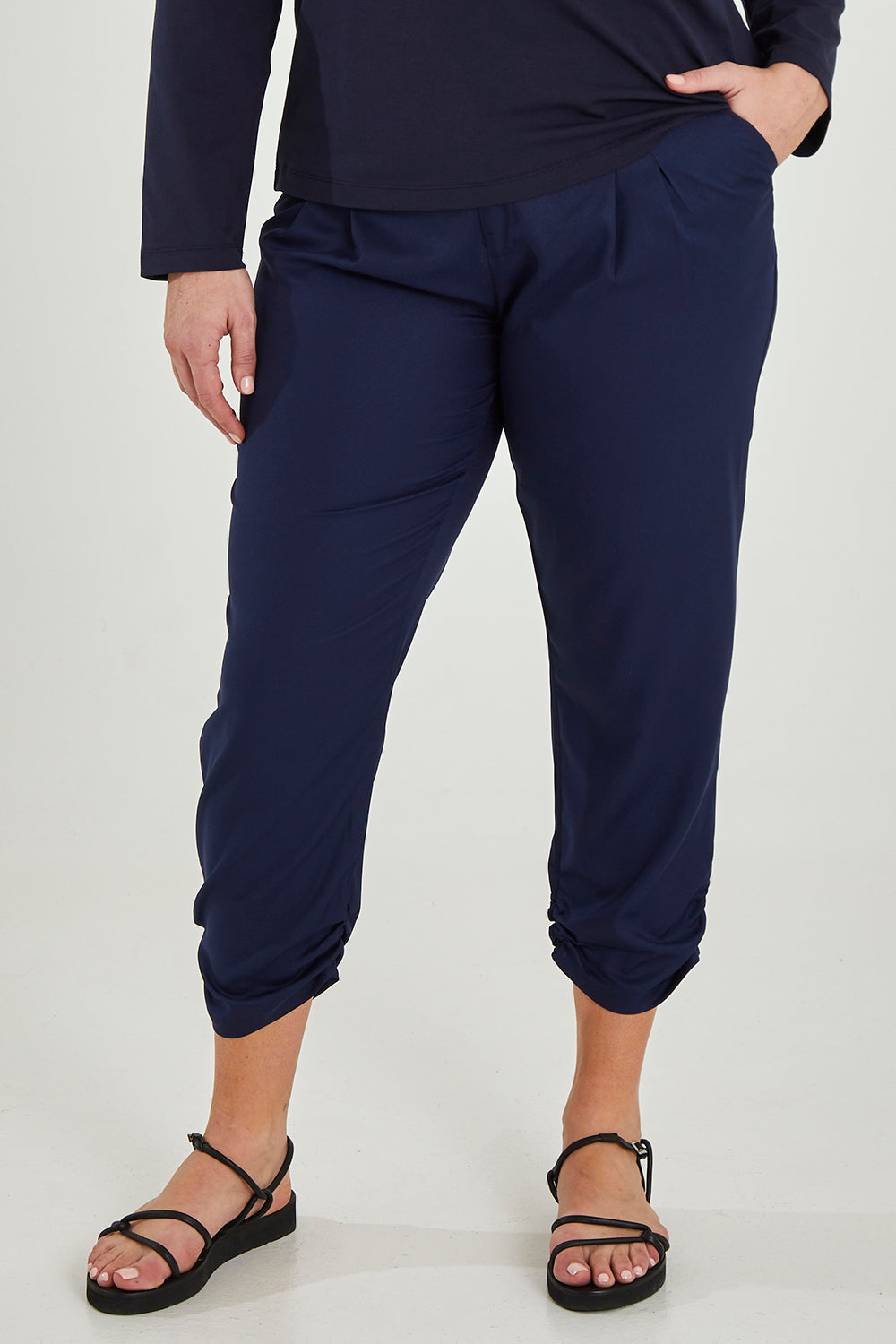 Model Maddy wearing size 16 of The Best Seller Pant in colour Navy (Blue), from the front, cropped image