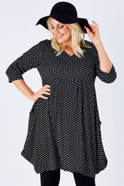 Model Natalie wearing size 16 of The Spot Pocket Tunic Dress in colour Spot (Black), from the front, cropped image