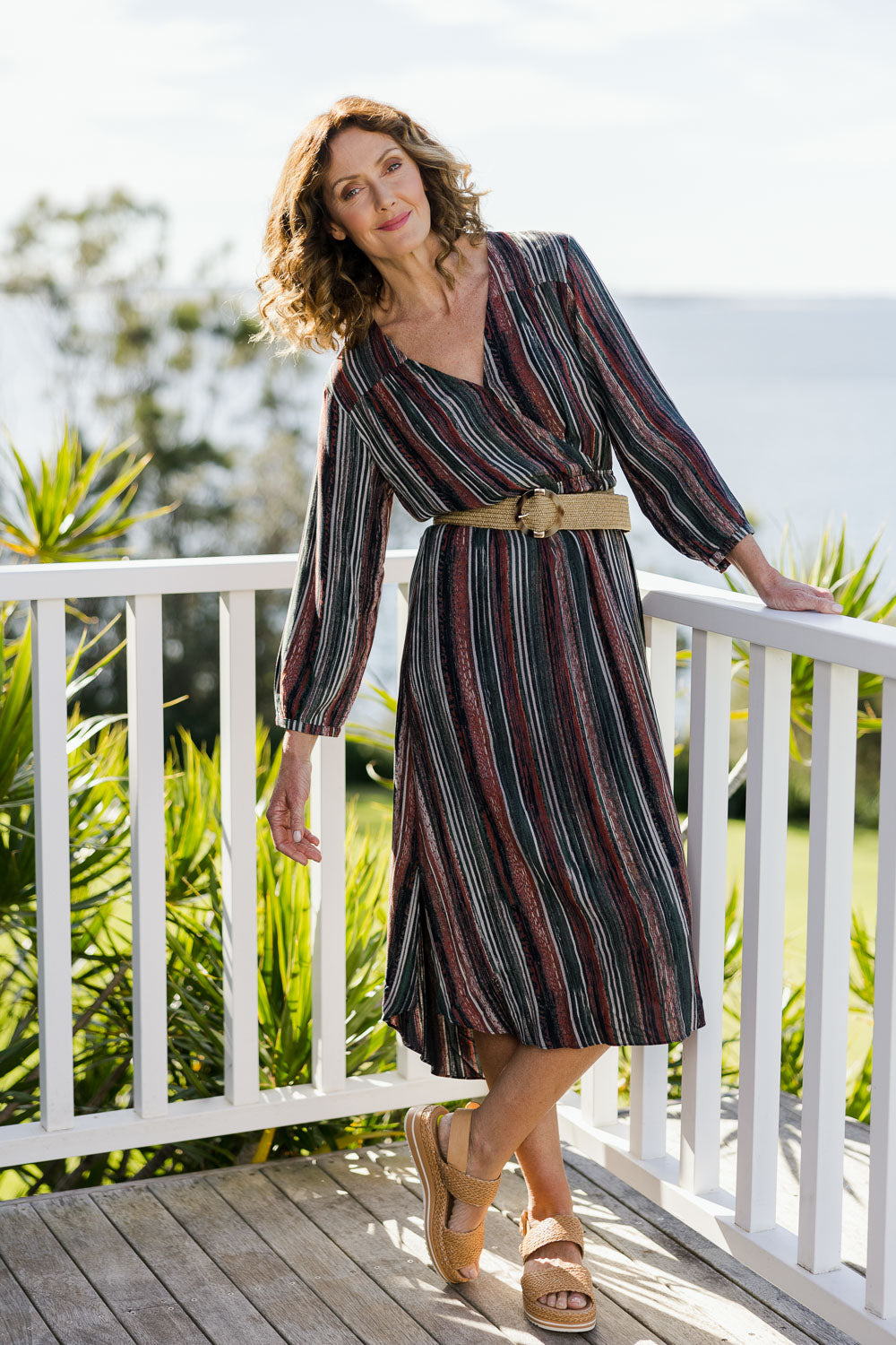 Model Emma wearing size 10 of The Wrap Front Midi Dress in colour Multistrip (Black), from the front, showing the whole outfit