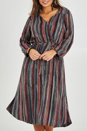 Model Monique wearing size 14 of The Wrap Front Midi Dress in colour Multistrip (Black), from the front, cropped image