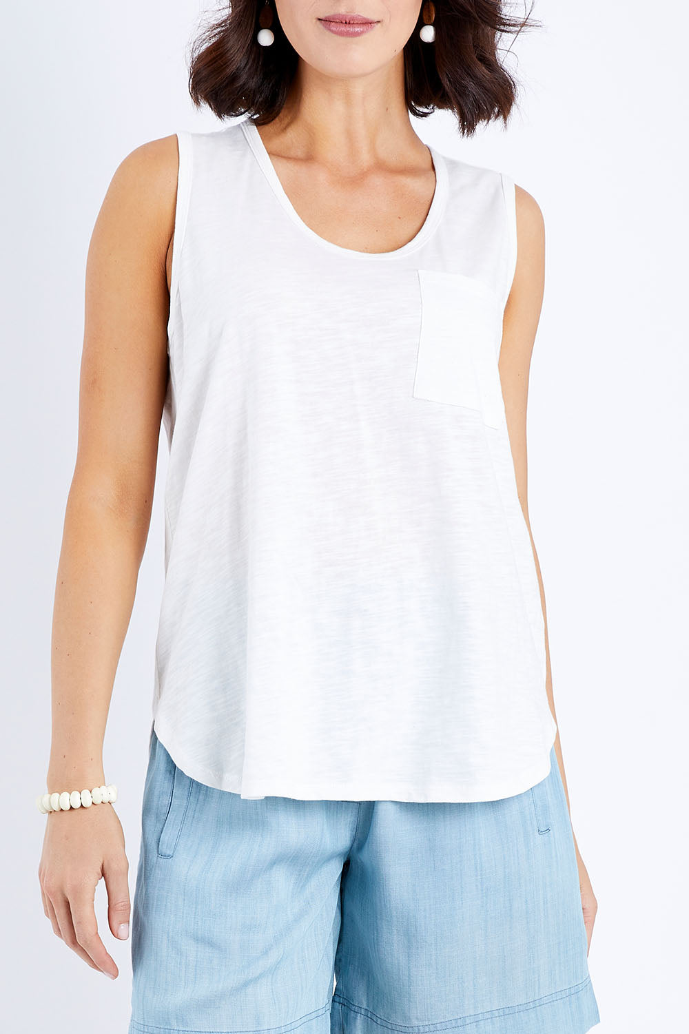 Model Andrea wearing size 10 of The Long Line Tank in colour White (White), from the front, cropped image