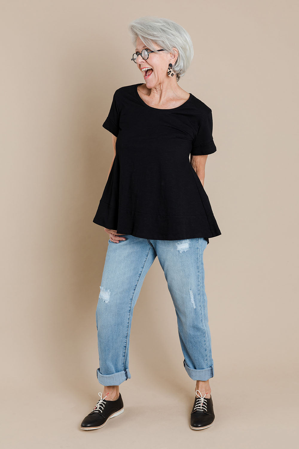 Model Elise wearing size 10 of The Short Sleeve Swing Tee in colour Black (Black), from the front, showing the whole outfit