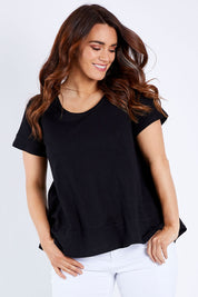 Model Laura wearing size 14 of The Short Sleeve Swing Tee in colour Black (Black), from the front, cropped image