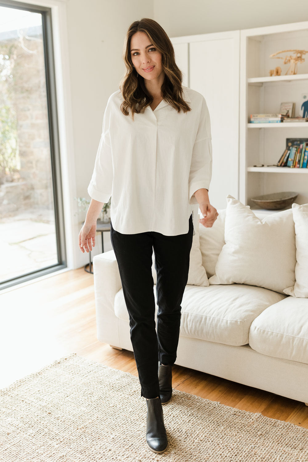 Model Madeline wearing size 10 of The Panel Detail Pant in colour Black (Black), from the front, showing the whole outfit