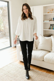 Model Madeline wearing size 10 of The Panel Detail Pant in colour Black (Black), from the front, showing the whole outfit