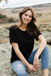 Model Madeline wearing size 10 of The Essential Pleat Detail Tee in colour Black (Black), from the front, showing the whole outfit