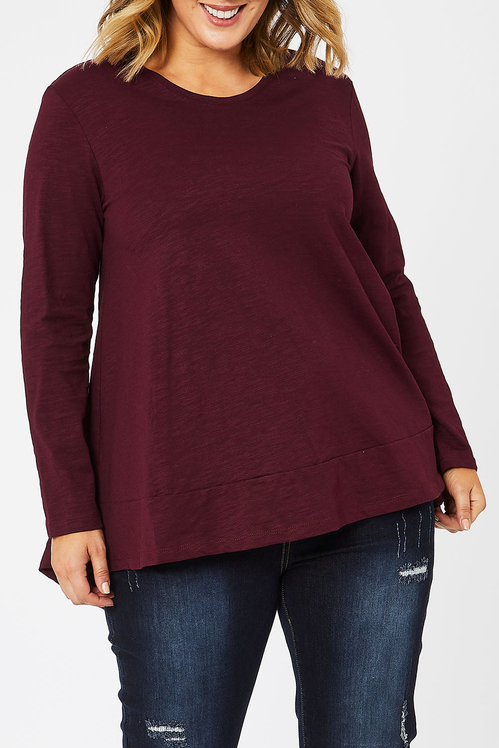 Model Jess wearing size 14 of The Long Sleeve Swing Tee in colour Shiraz (Red), from the front, cropped image