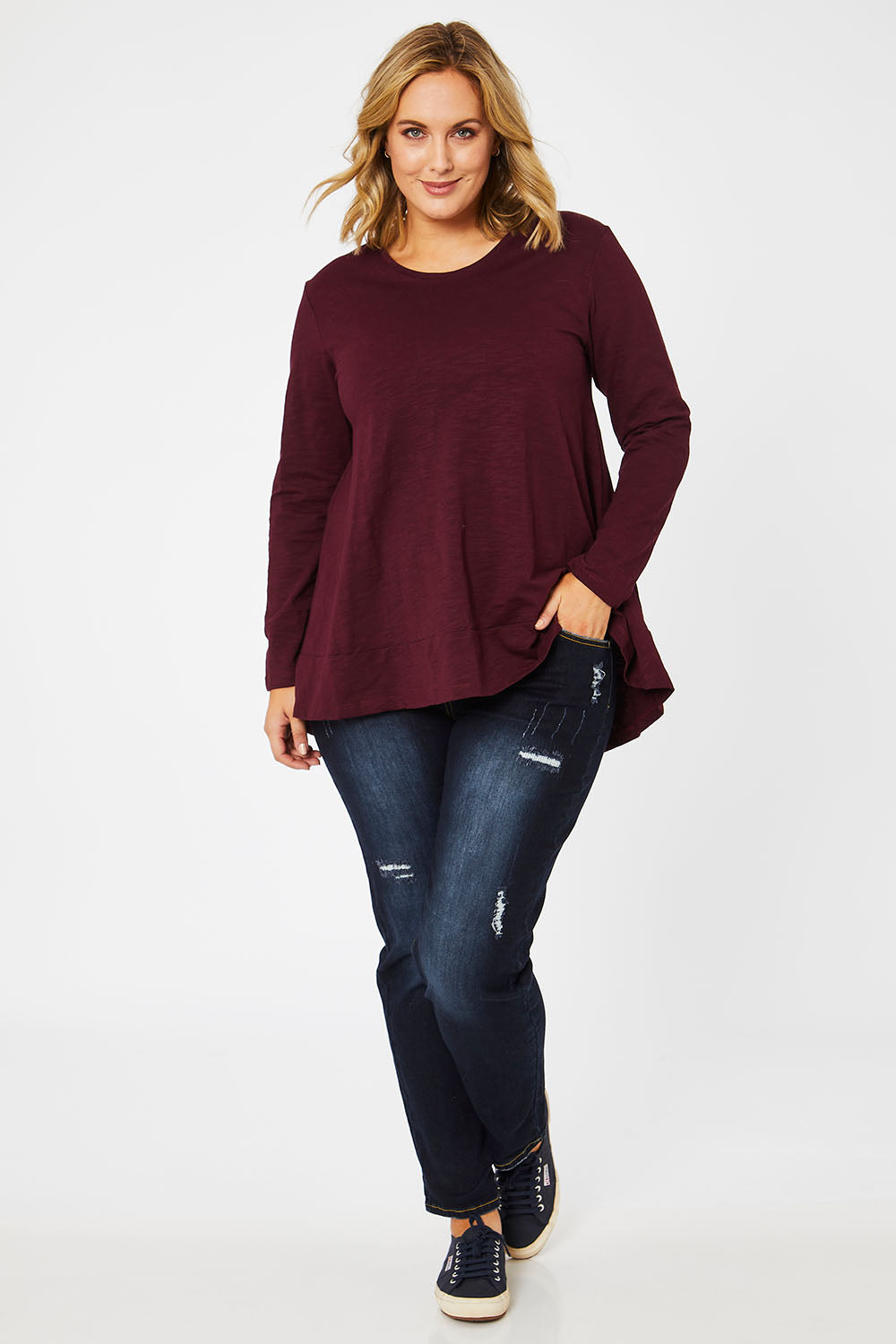 Model Jess wearing size 14 of The Long Sleeve Swing Tee in colour Shiraz (Red), from the front, showing the whole outfit