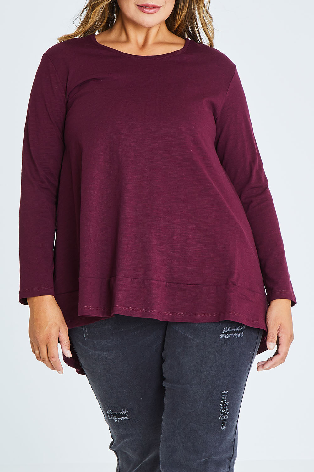 Model Palatina wearing size 16 of The Long Sleeve Swing Tee in colour Shiraz (Red), from the front, cropped image