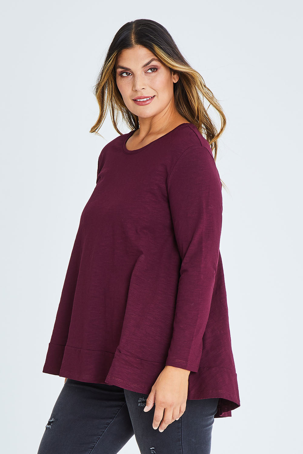 Model Palatina wearing size 16 of The Long Sleeve Swing Tee in colour Shiraz (Red), from the front, cropped image
