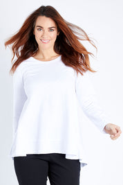 Model Laura wearing size 12 of The Long Sleeve Swing Tee in colour White (White), from the front, cropped image