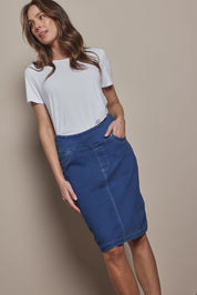 Model Madeline wearing size 10 of The Pull On Denim Skirt in colour Denim (Blue), from the front, cropped image