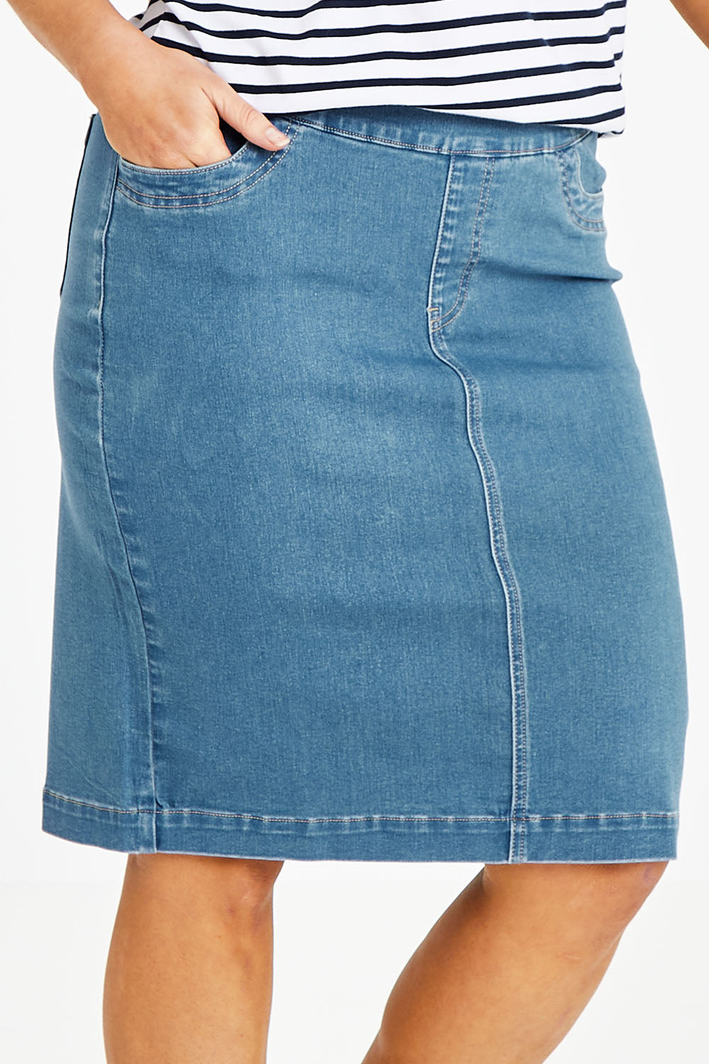 Model Laura wearing size 14 of The Pull On Denim Skirt in colour Middenim (Blue), from the front, cropped image