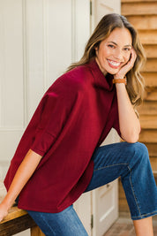 Model Amanda wearing size S of The Roll Neck Easy Wear Jumper in colour Shiraz (Red), from the front, showing the whole outfit