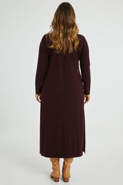 Model Laura wearing size L of The Comfort True Knit Dress in colour Burntplum (Purple), from the back