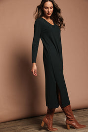 Model Madeline wearing size S of The Comfort True Knit Dress in colour Darkpine (Green), from the front, showing the whole outfit