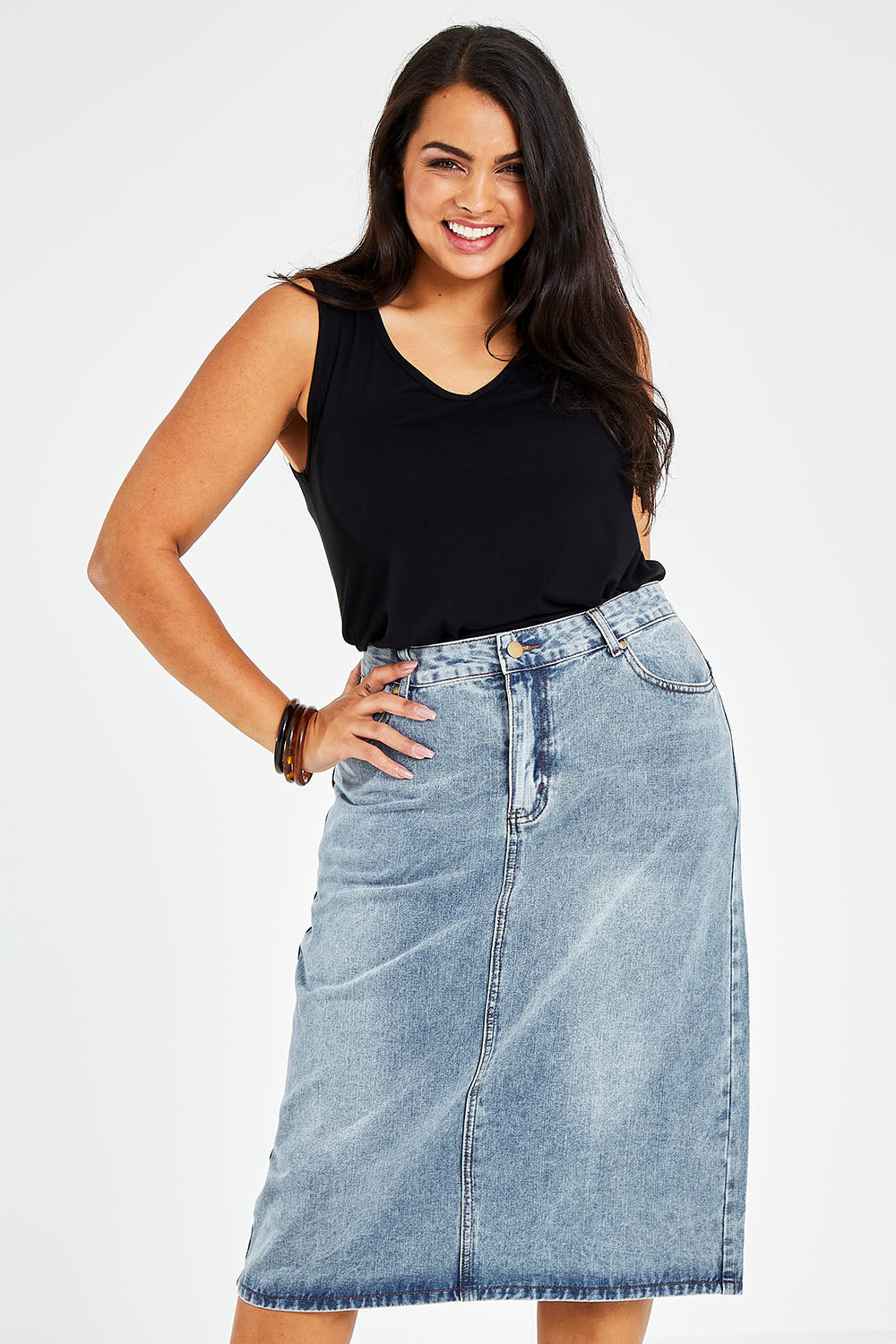 Model Sasha-Lee wearing size 16 of The Midi Denim Skirt in colour Denim (Blue), from the front, cropped image