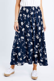Model Andrea wearing size 10 of The Pull On Swing Print Skirt in colour Daisyprint (Blue), from the front, cropped image