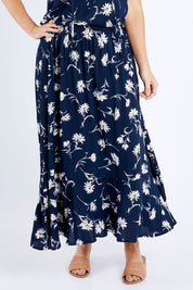 Model Laura wearing size 14 of The Pull On Swing Print Skirt in colour Daisyprint (Blue), from the front, cropped image
