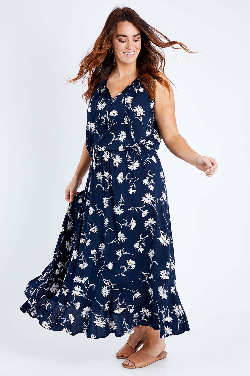 Model Laura wearing size 14 of The Pull On Swing Print Skirt in colour Daisyprint (Blue), from the front, showing the whole outfit