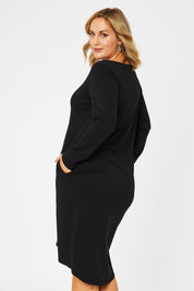 Model Jess wearing size 14 of The V Neck Essential Ponte Dress in colour Black (Black), from the back