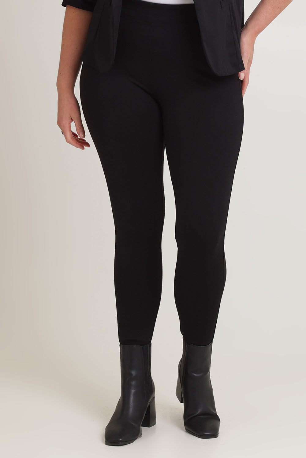 Model Chanel wearing size 16 of The Essential Ponte Legging in colour Black (Black), from the front, cropped image