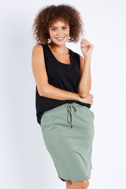 Model Lala wearing size 10 of The Drawcord Skirt in colour Khaki (Green), from the front, cropped image